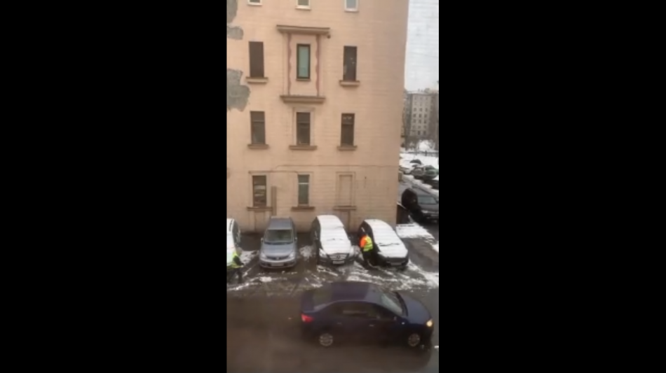 Петербуржцы заметили, как дворники у одного из домов убирают снег под машины